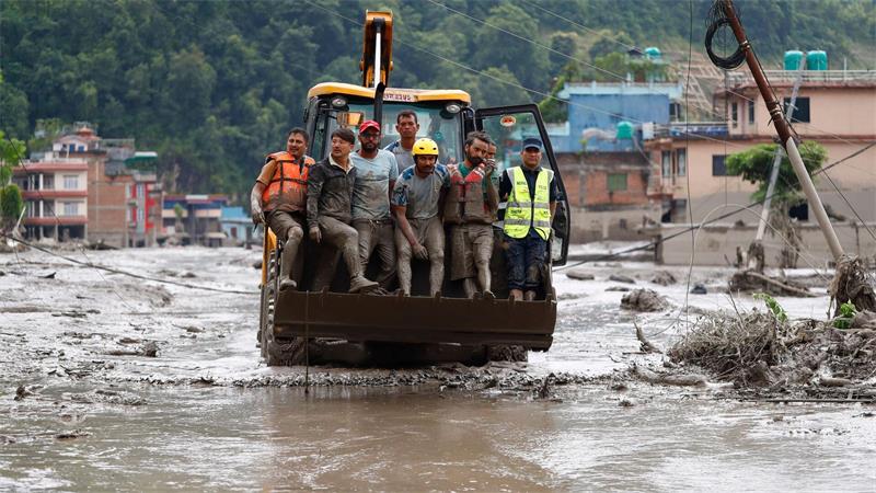 Einsatzkräfte retten nach einer Sturzflut im Distrikt Nuwakot in Nepal Menschen mit einer Planierraupe aus Gebäuden und der Infrastruktur, die entlang des angeschwollenen Trishuli-Flusses beschädigt wurden.