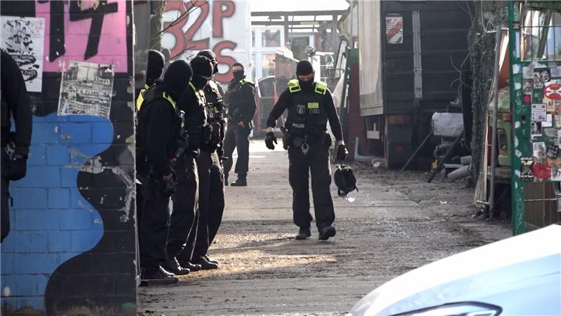 LKA: Bauwagen wohl Unterkunft von gesuchtem Ex-Terroristen Einsatzkräfte stehen an einem Grundstück.