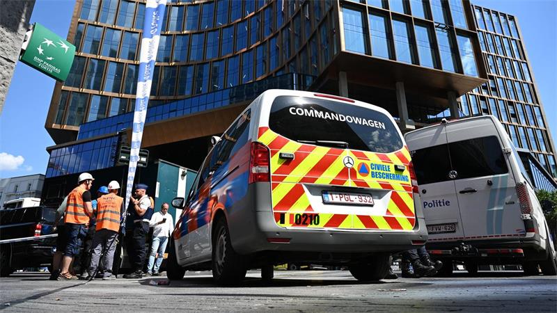 Einsatzkräfte stehen vor dem Gebäude bei einem Brand in der Brüsseler Innenstadt.