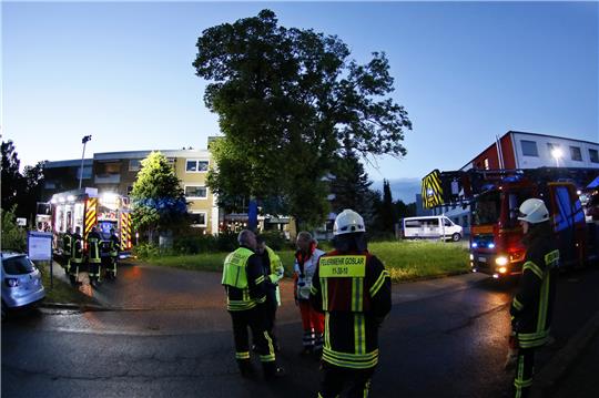 Einsatzkräfte stehen vor der Wohnanlage, in der es am frühen Mittwochmorgen gebrannt hat. Foto: Epping