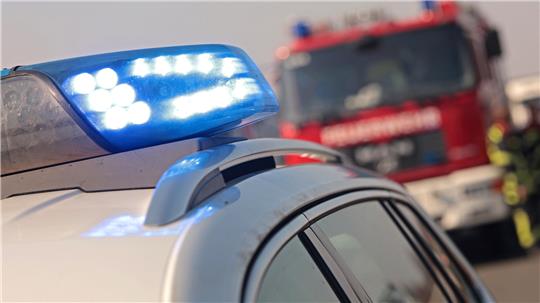 Blaulicht von einem Polizeiauto und im Hintergrund steht ein Fahrzeug der Feuerwehr