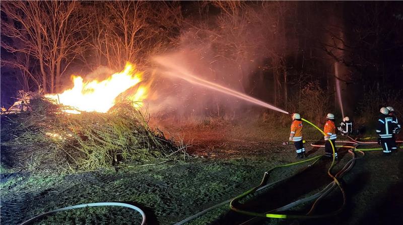 Die Feuerwehr löscht ein Osterfeuer.