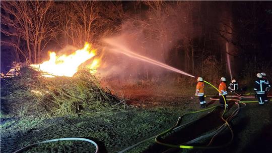 Die Feuerwehr löscht ein Osterfeuer.