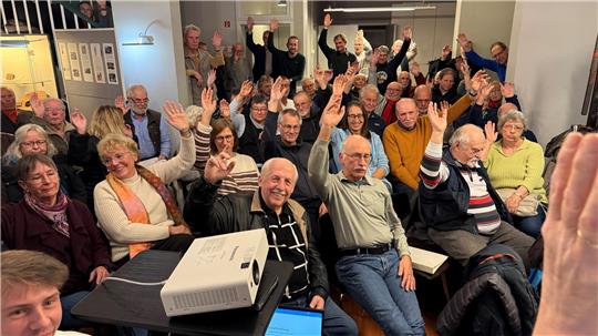 Die Mitglieder des Oberharzer Geschichts- und Museumsvereins heben ihre Arme, um ihre Stimme zu geben.