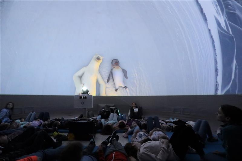 Eisbär Vladimir und Pinguin James betrachten den funkelnden Sternenhimmel inmitten der Polarnacht und sind davon ebenso angetan wie die Astfelder Grundschüler, die es sich im Zelt ebenfalls gemütlich gemacht haben. Foto: Neuendorf