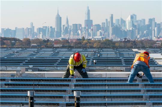 Elektriker installieren im New Yorker Stadtteil Queens Solarpaneele. Die US-Regierung hebt Zoll-Ausnahmen für bestimmte Solar-Importe auf.