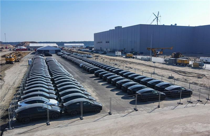 Elektrofahrzeuge vom Typ Tesla Model Y stehen aufgereiht vor der Tesla Gigafactory in Grünheide.