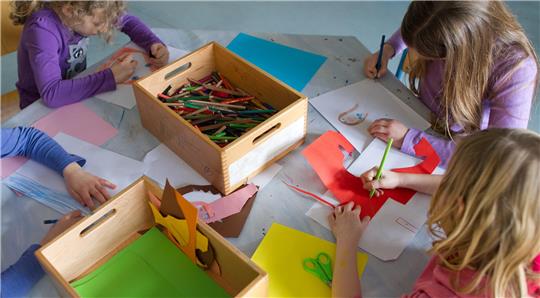 Grundschulkinder sind mit Bastelarbeiten beschäftigt.