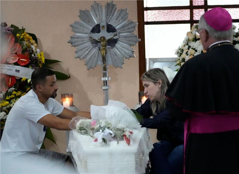 Trauer in Blumenau: Getötete Kinder nach Angriff beerdigt Eltern sitzen während einer Totenwache in Blumenau neben dem Sarg mit den sterblichen Überresten ihrer siebenjährigen Tochter, die in der Kinderkrippe getötet wurde.