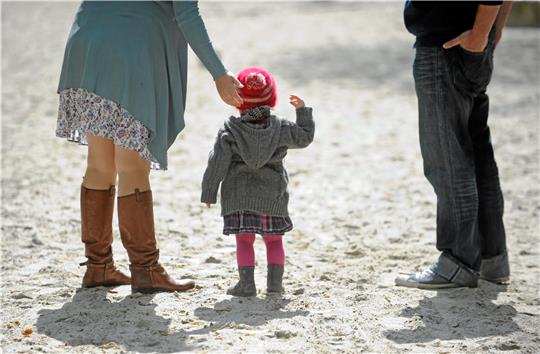 Eltern und Kind laufen auf einem Strand. Der CDU-Kreistagsabgeordnete Frank Oesterhelweg hat beim Landkreis Wolfenbüttel Fragen zur Situation von Pflegefamilien gestellt. Foto: picture alliance/dpa