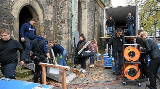 Emsiges Treiben wie im Ameisenhaufen: Zahlreiche Menschen fassen mit an, um die Goslarer Marktkirche ins rechte Licht zu setzen und für die Fernseh-Übertragung am Reformationstag zu verkabeln.