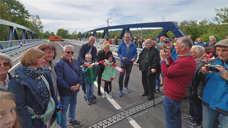Das Foto zeigt Vienenburger Bürger, Goslars Oberbürgermeisterin Urte Schwerdtner und Ortsvorsteher Martin Mahnkopf, die ein Band zur Freigabe der neuen Brücke durchschneiden.