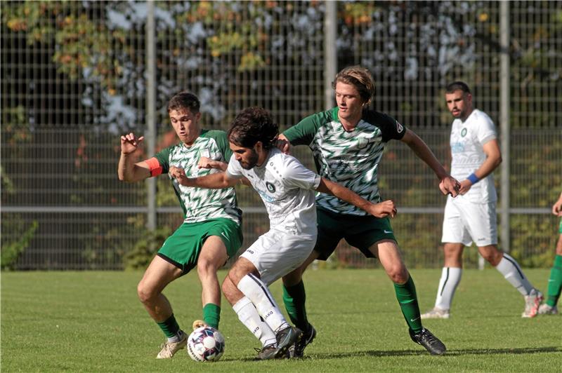 Hausdörfer-Hattrick lässt den SC 18 Harlingerode jubeln Enes Fidan, der den Treffer zum 1:0 für den VfL Oker erzielt, wird von zwei Spielern des TSV Üfingen bearbeitet. Die Gäste vom Kanal nehmen mit einem 4:2 die Punkte mit. Foto: Gietemann