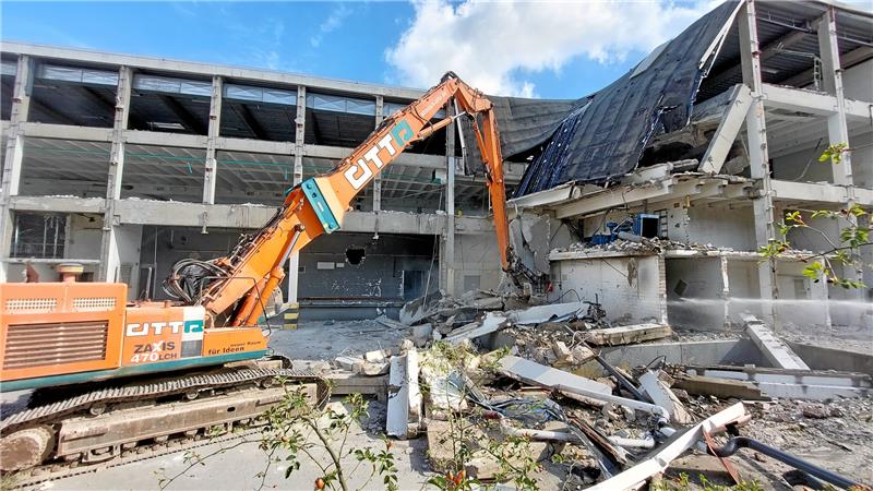 Er wirbelt bisweilen Staub auf: Ein Bagger frisst sich durch die Überreste des alten Real-Markts. Foto: Neuendorf