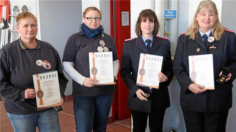 Vier Frauen präsentieren ihre Urkunden.