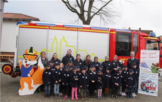 Erinnerung an die Gründung der Kinderfeuerwehr für das Gebiet der ehemaligen Samtgemeinde Lutter: Die Feuerfüchse stellen sich mit ihren Betreuern, Ortsbürgermeisterin Karin-Rösler-Brandt (li.) und Stadtbrandmeister Matthias Brunke (re.) zum Foto auf.