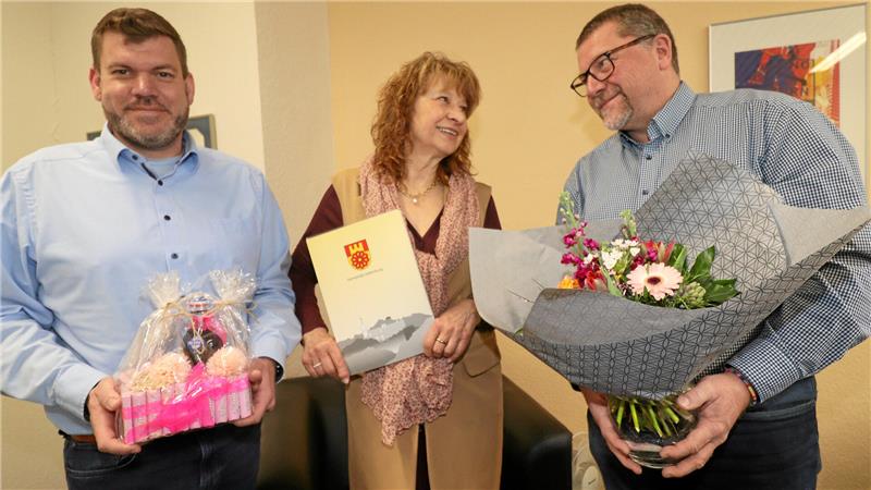 Nach 2500 Trauungen ist für Liebenburgs Standesbeamtin Schluss Zwei Männer und eine Frau mit Präsent, Urkunde und Blumen in der Hand blicken in die Kamera.
