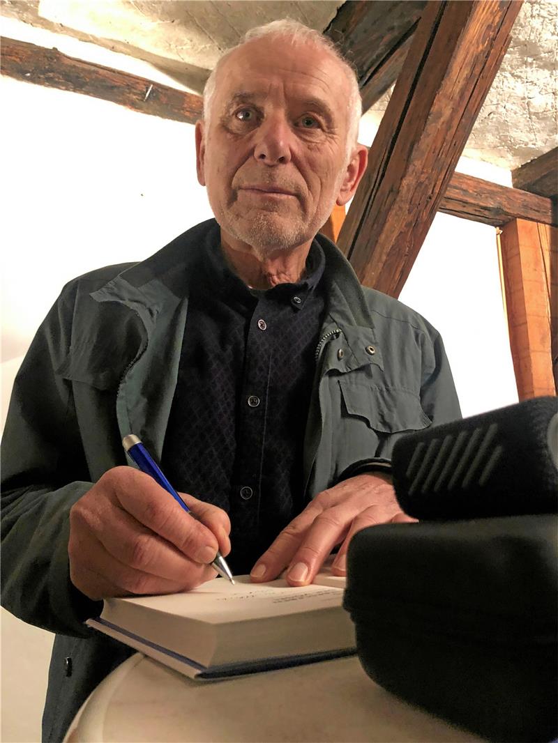 Ernst Paul Dörfler signiert eine Ausgabe seines jüngsten Buches.  Foto: Stade