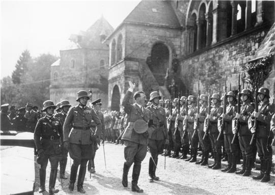 Erwin Rommel (l.) und Hitler schreiten am 30. September 1934 eine Kompanie an der Kaiserpfalz ab. Die Stelen informieren über die NS-Zeit in der Kaiserstadt und führen weiter zum digitalen Projekt „Goslar im Nationalsozialismus“. Foto: Bundesarchiv
