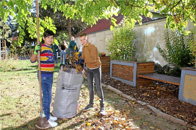 Es müssen auch die Blätter zusammengekehrt werden. Elias (11) und Lucas (11) erledigen das in Teamwork.