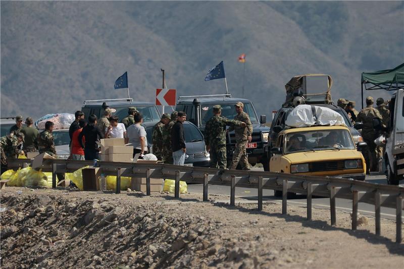 Fast 100.000 Flüchtlinge aus Berg-Karabach in Armenien Ethnische Armenier aus Berg-Karabach und Beobachter der Europäischen Union fahren mit ihren Autos an einem Kontrollpunkt auf der Straße von Berg-Karabach nach Goris vorbei.