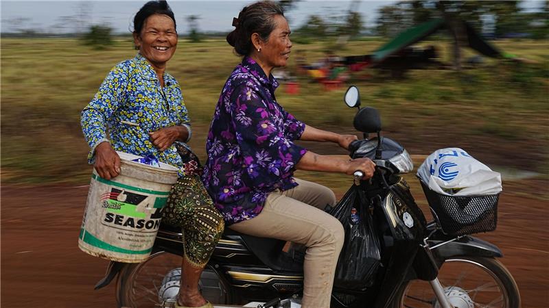 Evakuierte tragen Wasser, als sie auf dem Reisfeld von Chonkal in der Provinz Oddar Meanchey in Kambodscha Zuflucht suchen, nachdem sie nach erneuten Kämpfen zwischen Thailand und Kambodscha aus ihrer Heimat geflohen sind.