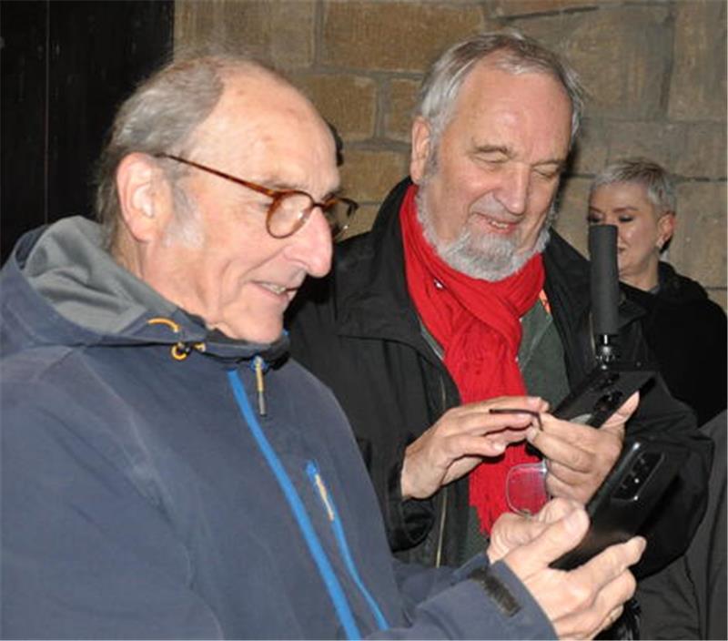 Auf zur Zeitreise: Der virtuelle Goslarer Dom ist freigeschaltet Zwei Männer schauen gebannt, aber lächelnd auf ihre Handys.