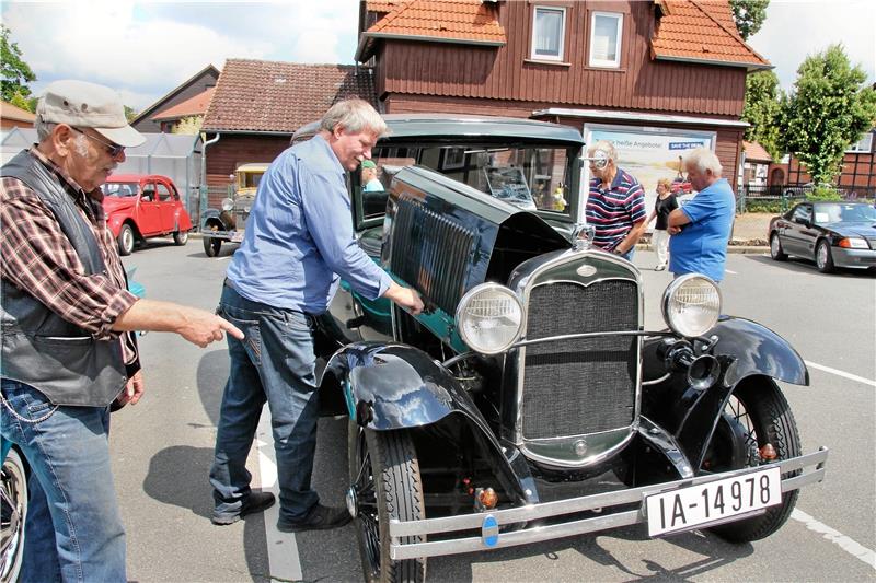 Fachsimpeln mit ganz viel Liebe zu Lack und Leder: Der Wolfenbüttler Konrad Merk (li.) wirkte als Statist in der Serie „Babylon Berlin“ mit, in der auch der dunkelgrüne Ford A Tudor von Siegfried Kirchner (2. v.li.) zu sehen ist. Beide sind schon für die Dreharbeiten der nächsten Staffel gebucht.  Fotos: Leifeld
