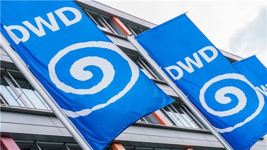 Fahnen mit dem Logo des Deutschen Wetterdienstes (DWD) flattern vor der Behörde.