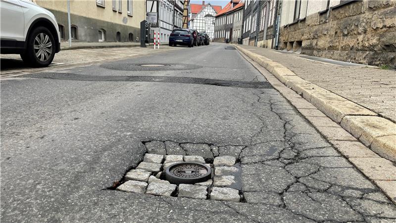 Das Bild zeigt die Mauerstraße in Goslar mit Löchern und Rissen im Asphalt.