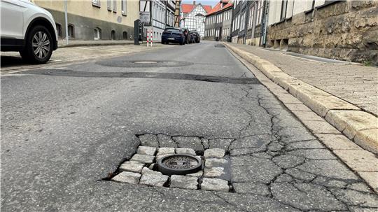 Das Bild zeigt die Mauerstraße in Goslar mit Löchern und Rissen im Asphalt.