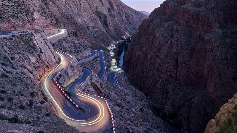 Fahrzeuge fahren über eine kurvige Straße durch das Dades-Tal im Hohen Atlas-Gebirge in Marokko.