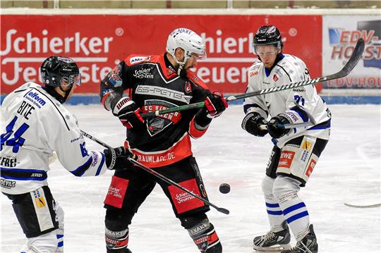 Falken-Stürmer Jörn Weikamp (M.) bemüht sich gegen die Timmendorfer Kristofers Bite (l.) und Jonah Henderson um Puckkontrolle. Fotos. Drechsler