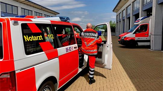 Ein Mann steigt in ein Notarztfahrzeug.