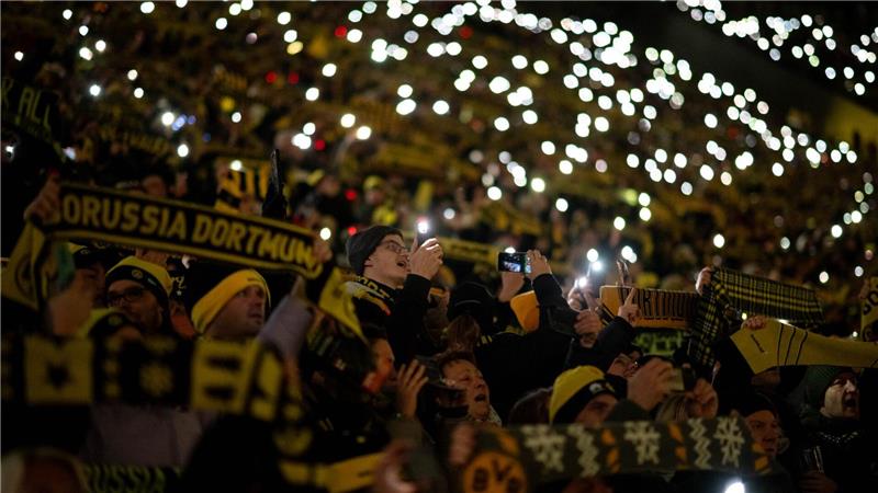 Fans stehen beim traditionellen Weihnachtssingen auf der Süd-Tribüne im BVB-Stadion.