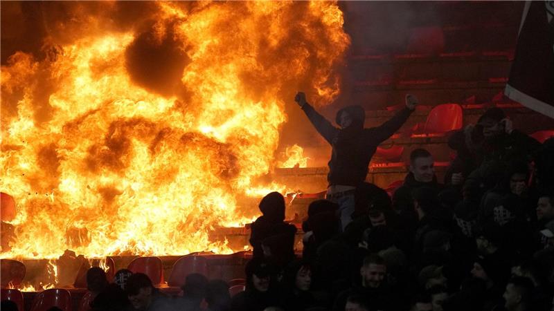 Fans von Partizan Belgrad jubeln vor brennenden Sitzen während des Derbys in der serbischen Fußballliga gegen Roter Stern Belgrad.