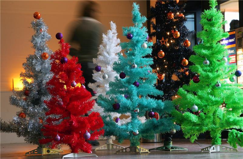 Darf es noch ein echter Weihnachtsbaum sein? Farbige Weihnachtsbäume aus Plastik. Wer sich für den klimakranken Wald engagieren will, muss nach Aussage des Forstamtsleiters nicht auf den Weihnachtsbaum verzichten oder zum Plastikbaum greifen. Foto: Gero Breloer/dpa