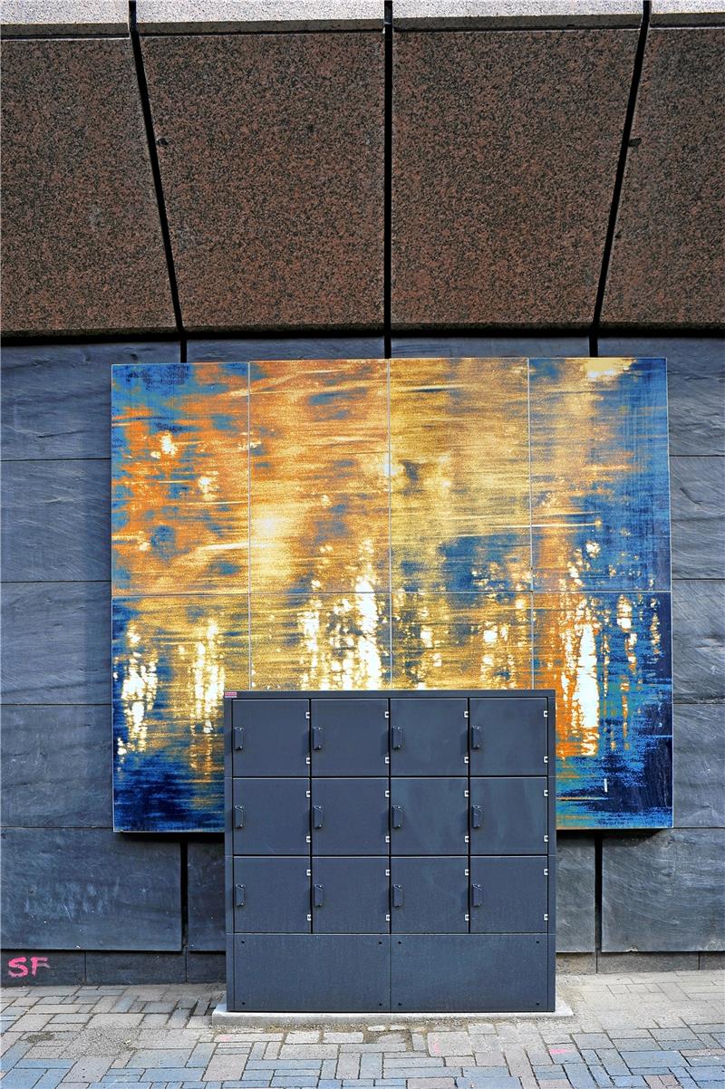 Goslarer Kunstmeile: Wenn aus einem Kunstfrevel neue Kunst wird „Farbverwirrung“: Emaille-Siebdruck aus dem Jahr 1998 von Heinz Janzen. Die durcheinander flirrenden Farben und unscharfen Konturen werden nun kontrastiert durch die harten Linien und die monochrome Oberfläche der Fahrradbox.