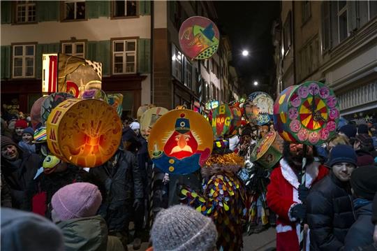 Fasnachtscliquen mit Laternen ziehen durch die Strassen am Morgestraich in Basel