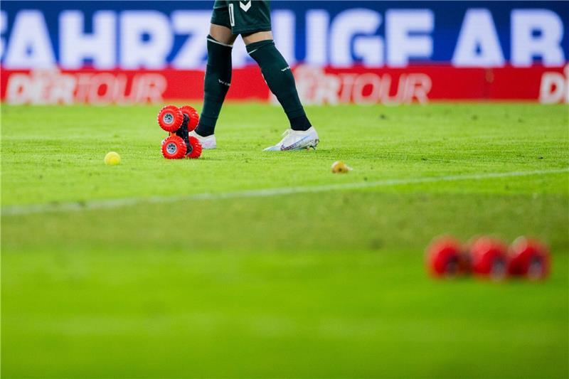 Proteste gegen DFL-Investor: Auch Spiel in Köln unterbrochen Ferngelenkte Autos fahren auf dem Spielfeld neben Tennisbällen.