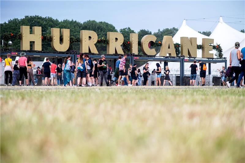 Festivalbesucher gehen 2022 am Haupteingang des Hurricane Festivals entlang.