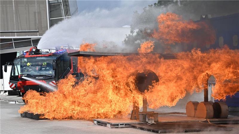 Feuerwehrkräfte löschen auf der Messe Interschutz mit einem Löschfahrzeug den simulierten Brand eines Flugzeugtriebwerkes. 