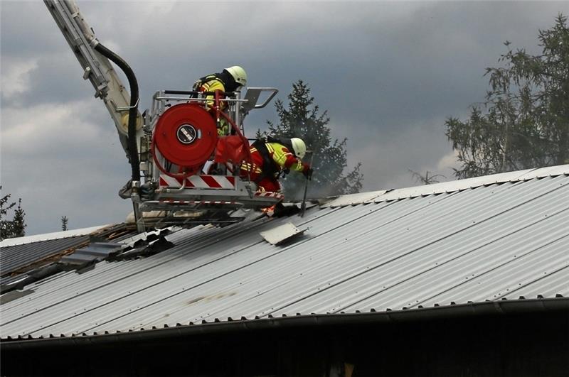 Palandsmühle: Brand in Baracke Feuerwehrkräfte öffnen das Blechdach der Wohnbaracke, um Glutnester zu finden und abzulöschen. Fotos: Leifeld