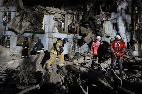 Feuerwehrleute des ukrainischen Katastrophenschutzes inspizieren ein beschädigtes Haus nach einem russischen Raketenanschlag.