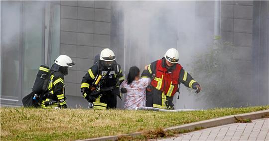 Feuerwehrleute holen die ohnmächtige Stefanie Bothe aus dem brennenden Gebäude.  Fotos: Epping