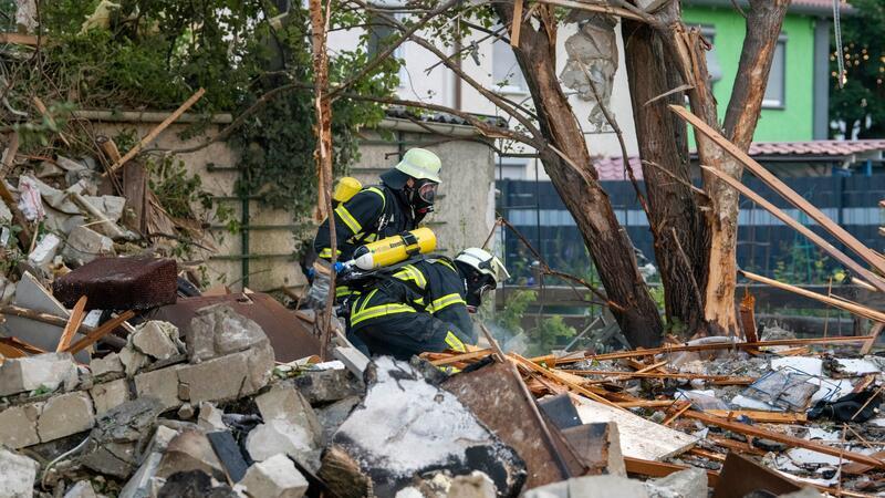 Feuerwehrleute in den Trümmern des zerstörten Hauses