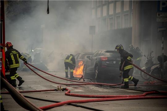 Feuerwehrleute löschen brennende Fahrzeuge.
