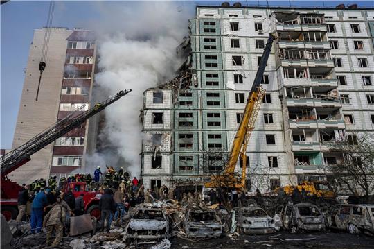 Feuerwehrleute löschen ein Feuer nach einem russischen Angriff auf ein Wohnhaus in der ukrainischen Stadt Uman.