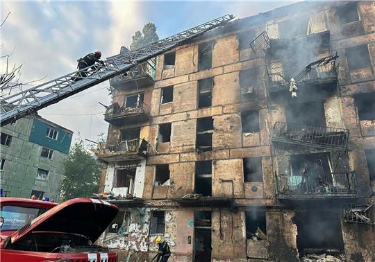 Feuerwehrleute löschen ein Feuer, nachdem Raketen in ein mehrstöckiges Wohnhaus eingeschlagen sind.