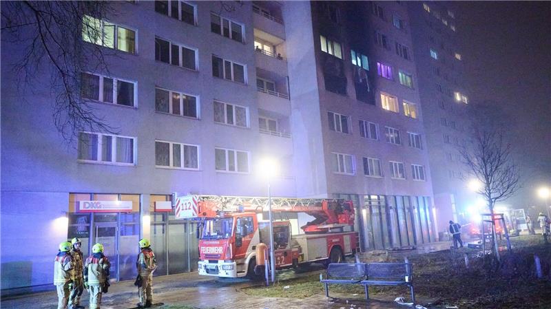 Zwei weitere Todesopfer nach Hochhausbrand in Berlin Feuerwehrleute stehen für Löscharbeiten vor einem Wohnhaus. (Archivbild)